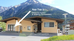 A building with a sign reading "SKI IN CASA HOTEL" and a mountain in the background. - A CASA Juwel - Ski in & Out Appartements (Soelden)