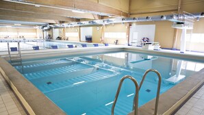 Une piscine intérieure dotée de plusieurs couloirs, de plots de départ et d’équipements de sécurité.