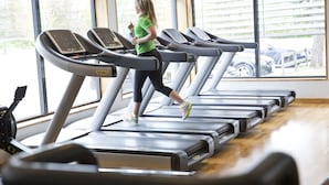 Une salle de sport équipée de tapis de course et d'appareils d'exercice.