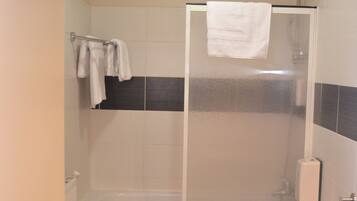 A bathroom with a shower enclosure, a toilet, and a sink.