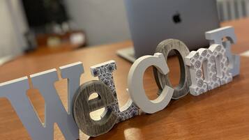 Een houten bureau met een 'Welcome' bord bestaande uit letters en cijfers.
