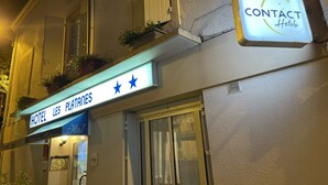 A hotel facade with illuminated signage for "HOTEL LES PLATAINES" and a "CONTACT Hotels" sign. -  Contact Hôtel les Platanes Villeneuve sur Lot Centre (Villeneuve-sur-Lot)