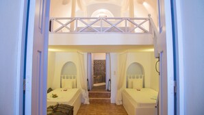 Una habitación con literas, una mesita con un florero y vista a una piscina.