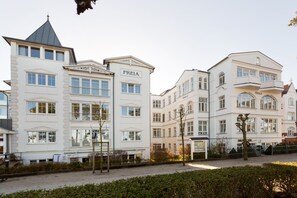A row of white buildings with "FREIA" and "FRIGGA" signs, indicating hotel names. - Villa Frigga & Villa Freia (Binz)