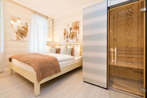 A bedroom with a bed, a nightstand, a lamp, and a wardrobe. - Villa Frigga & Villa Freia (Binz)