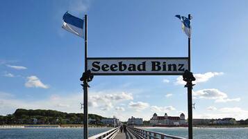 Un muelle con un letrero que dice 'Seebad Binz' bajo un cielo despejado.