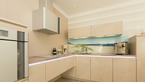A modern kitchen with built-in appliances, a large island, and a view of the ocean.