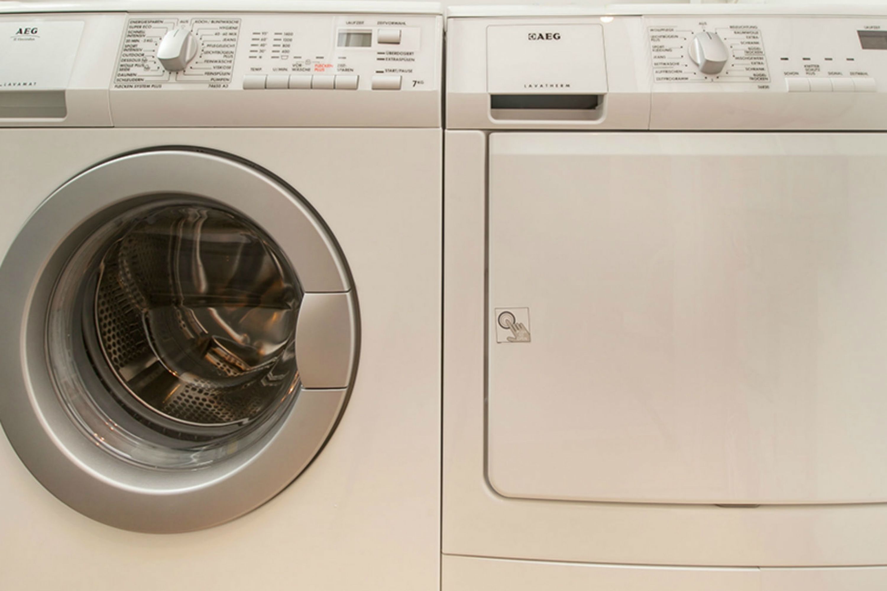 A front view of a front-loading washing machine with a control panel and a dryer compartment.