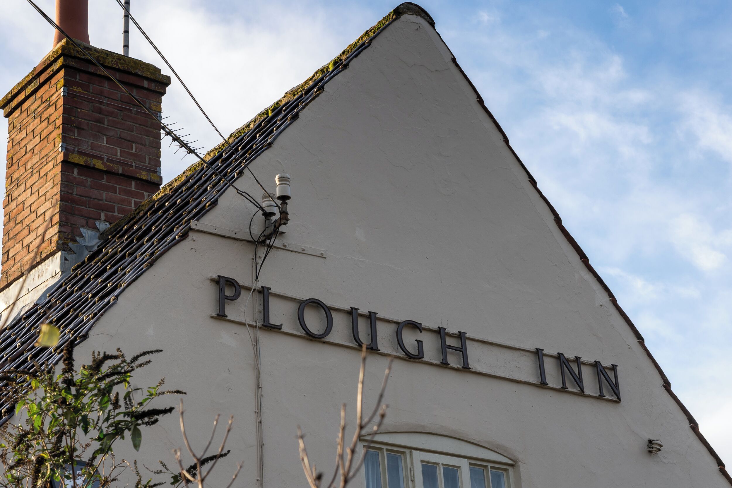 A building with the sign "Plough Inn" on its facade.