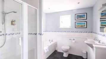 Een moderne badkamer met een douchecabine van glas, een toilet, een wastafel en een klein raam.