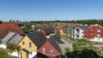A residential area with various houses and apartment buildings, featuring different roof styles and colors.