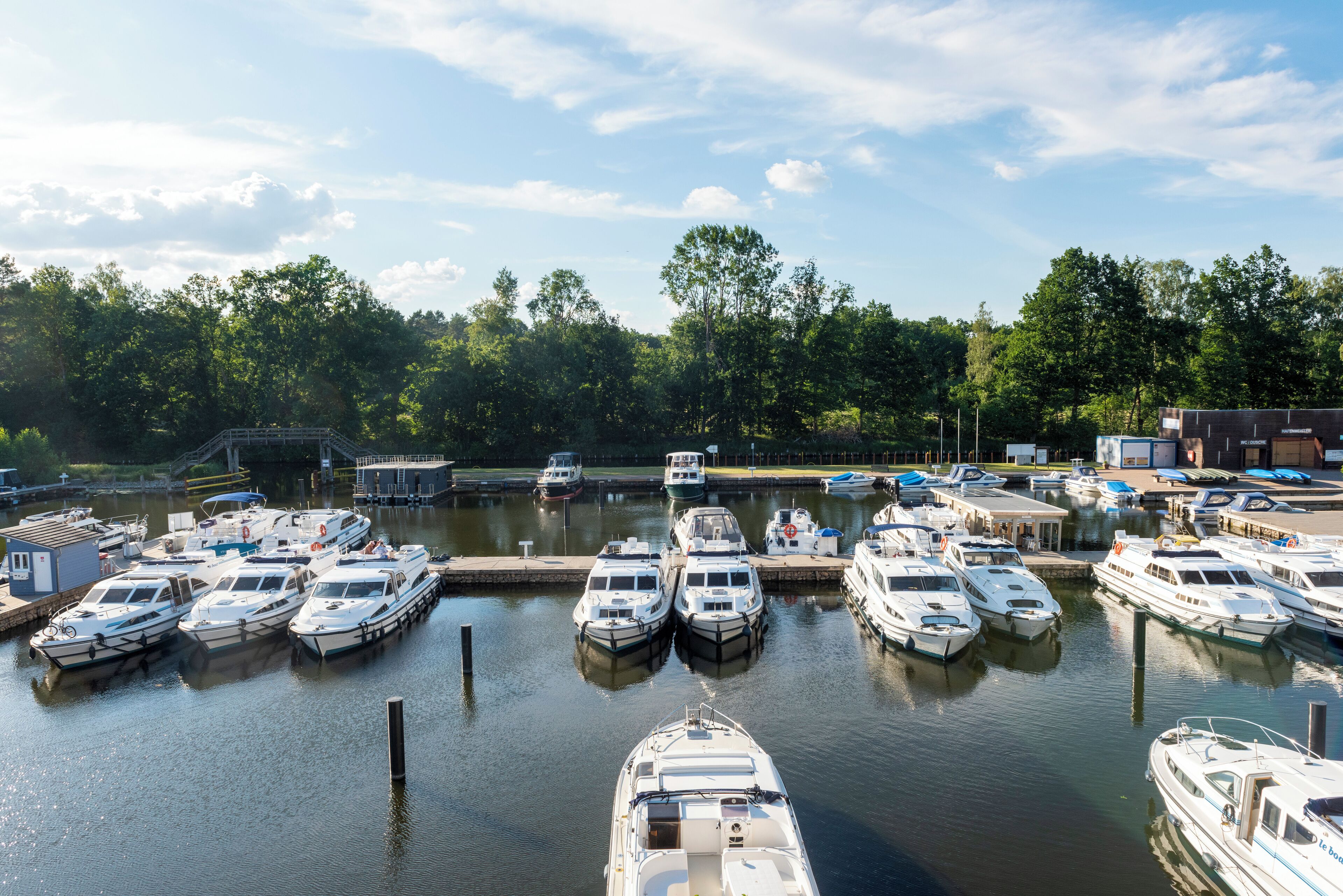A marina with multiple boats docked at the pier.
