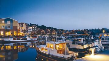 A marina with boats docked, surrounded by multi-story buildings with balconies and windows.