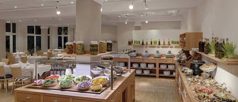 Uma mesa de buffet com diversos alimentos e acompanhamentos.