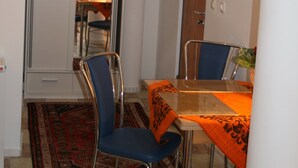 A compact dining area with a table, chairs, and a mirror above the table.