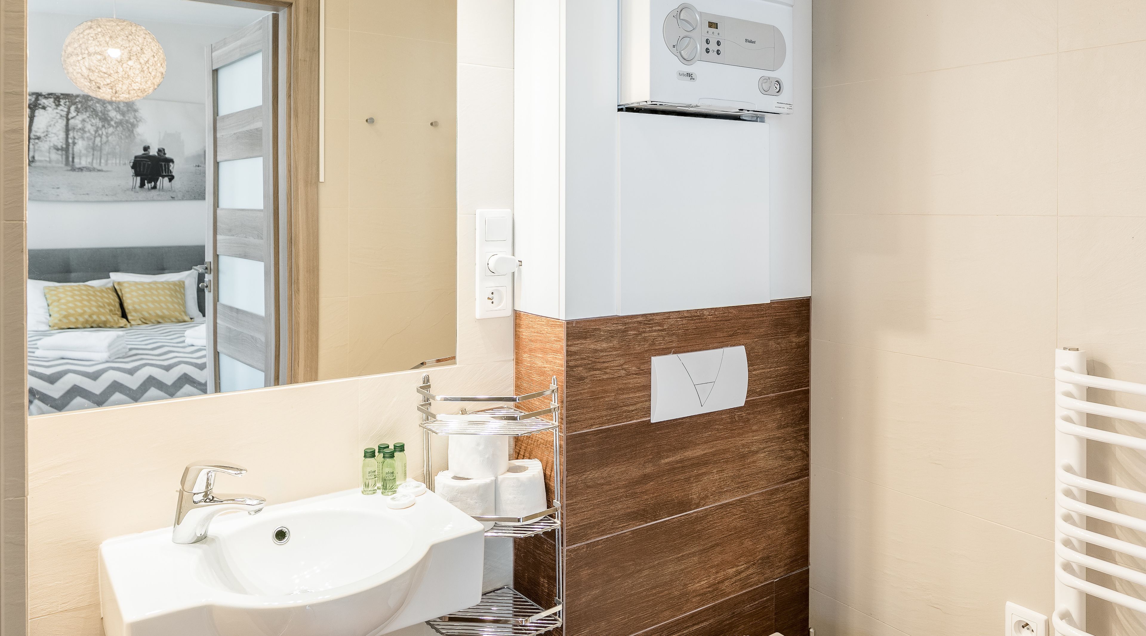 Une salle de bain moderne avec un lavabo, un miroir et un porte-serviettes.