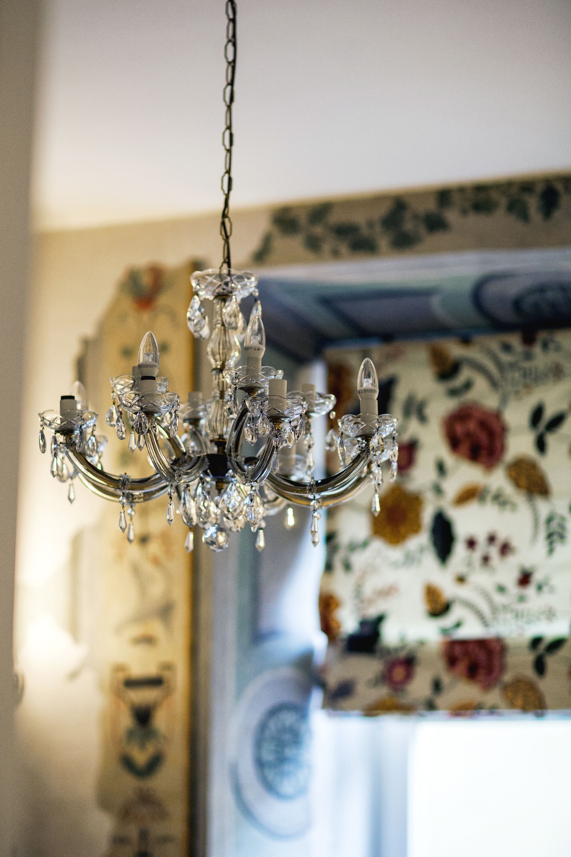 Een kroonluchter met meerdere armen en kristallen decoraties.