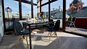 A modern dining area with a glass partition, a dining table, and chairs.