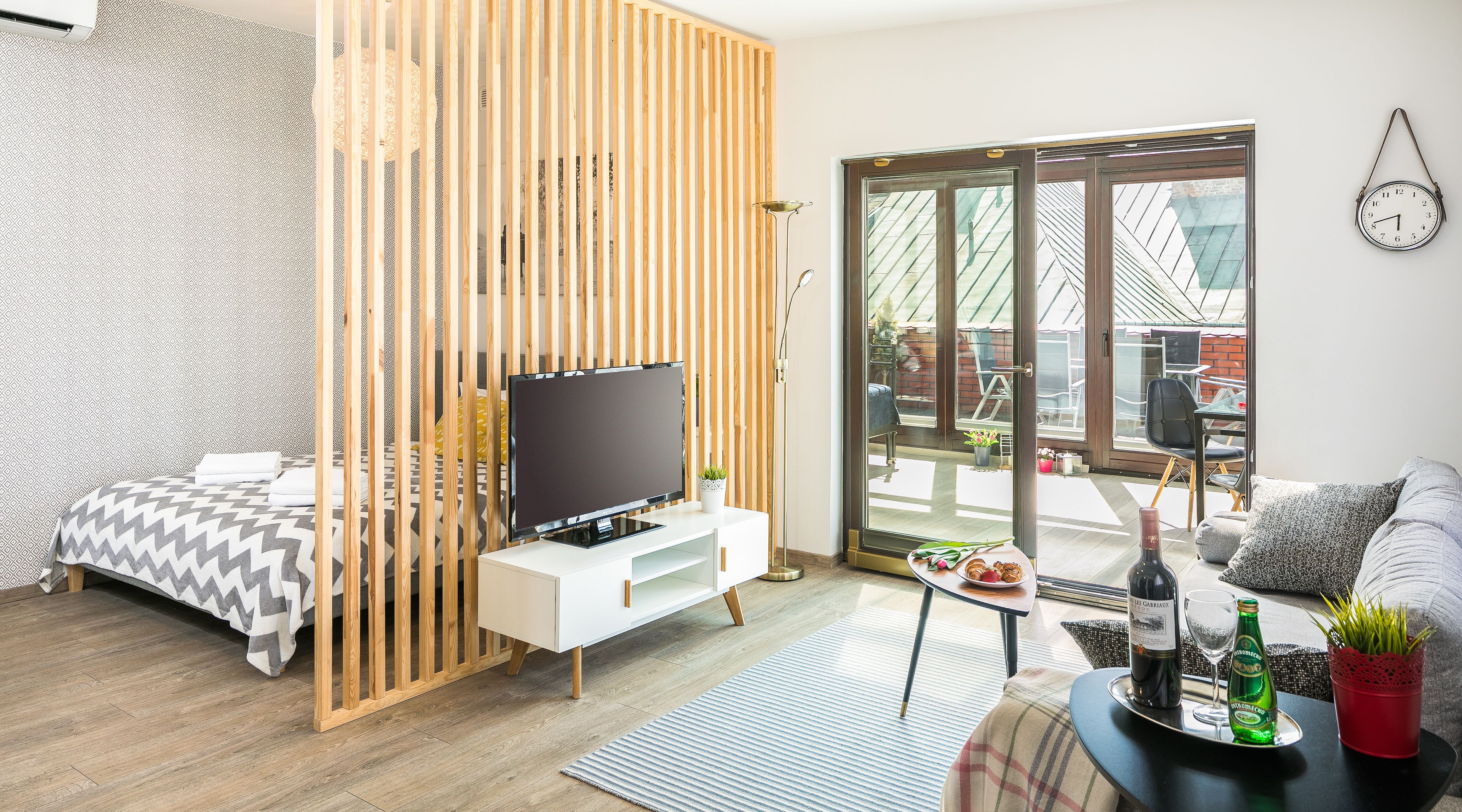 A modern living room with a TV, sofa, and dining area.
