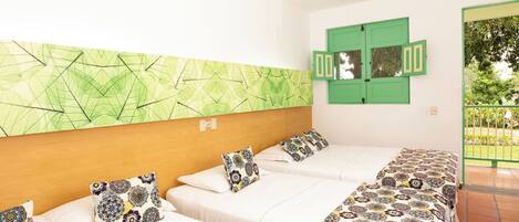 Una camera d'albergo con due letti, un quadro decorativo verde e una porta verde.