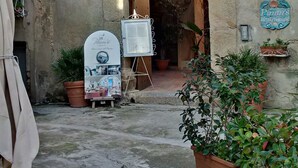 Un patio al aire libre con un edificio rústico, un arco de madera y un letrero que dice 'Pimm's Restaurant'.