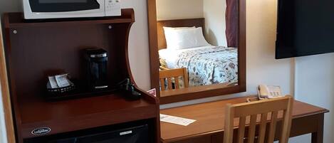 Une chambre d’hôtel équipée d’un bureau, d’un four à micro-ondes, d’une machine à café, d’un téléphone et d’une télévision.