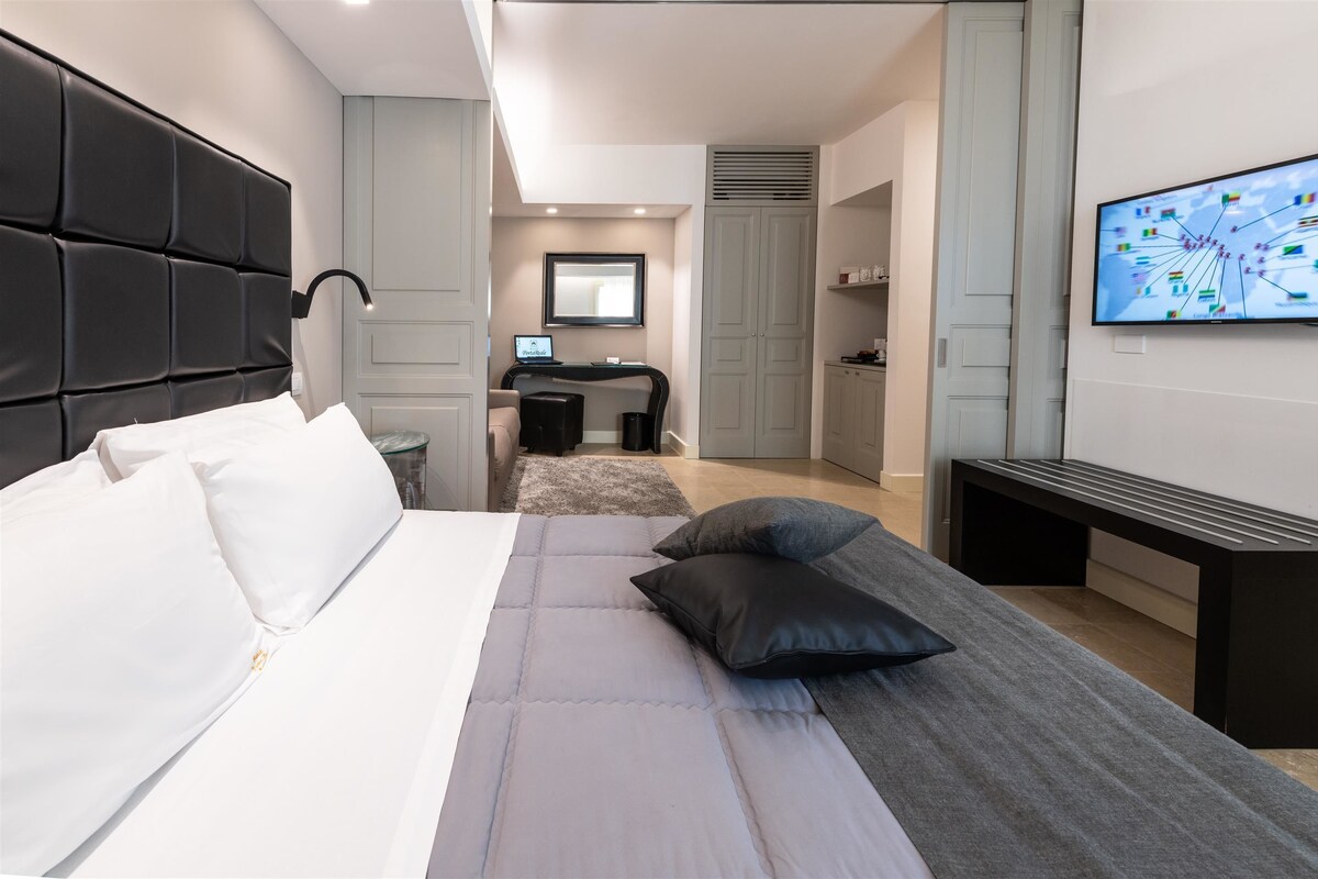 Una habitación de hotel moderna con una cama grande, un escritorio y un televisor.