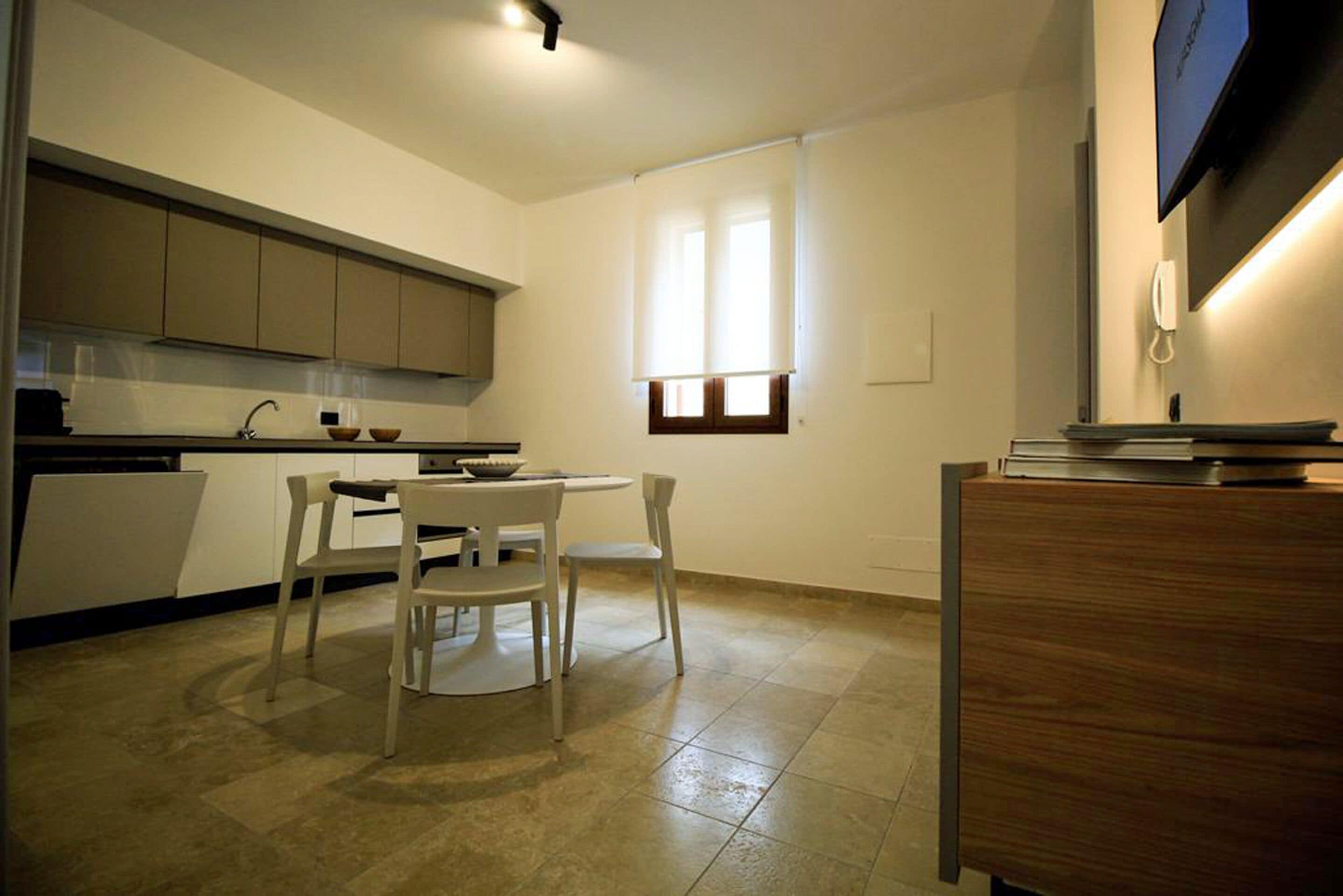 Una cocina moderna con comedor, un mueble de madera y una ventana con persianas.