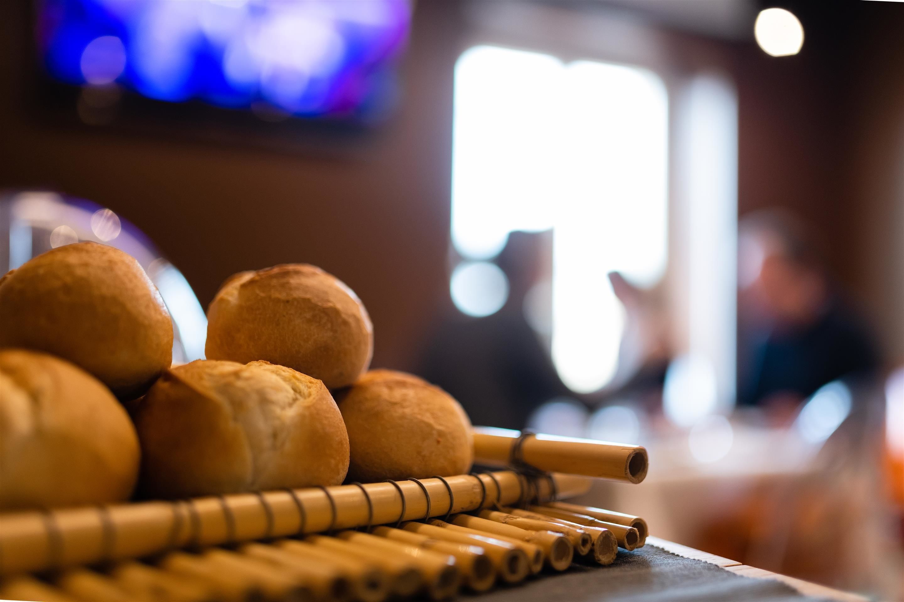 A table with bread rolls and bamboo sticks.