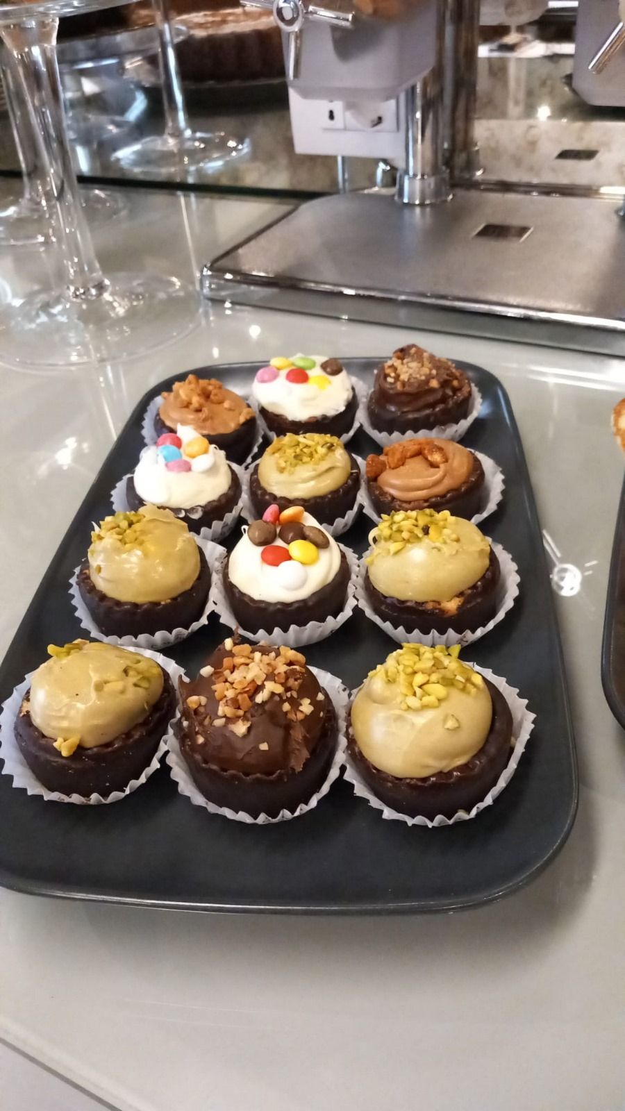 A tray of assorted cupcakes with various toppings.