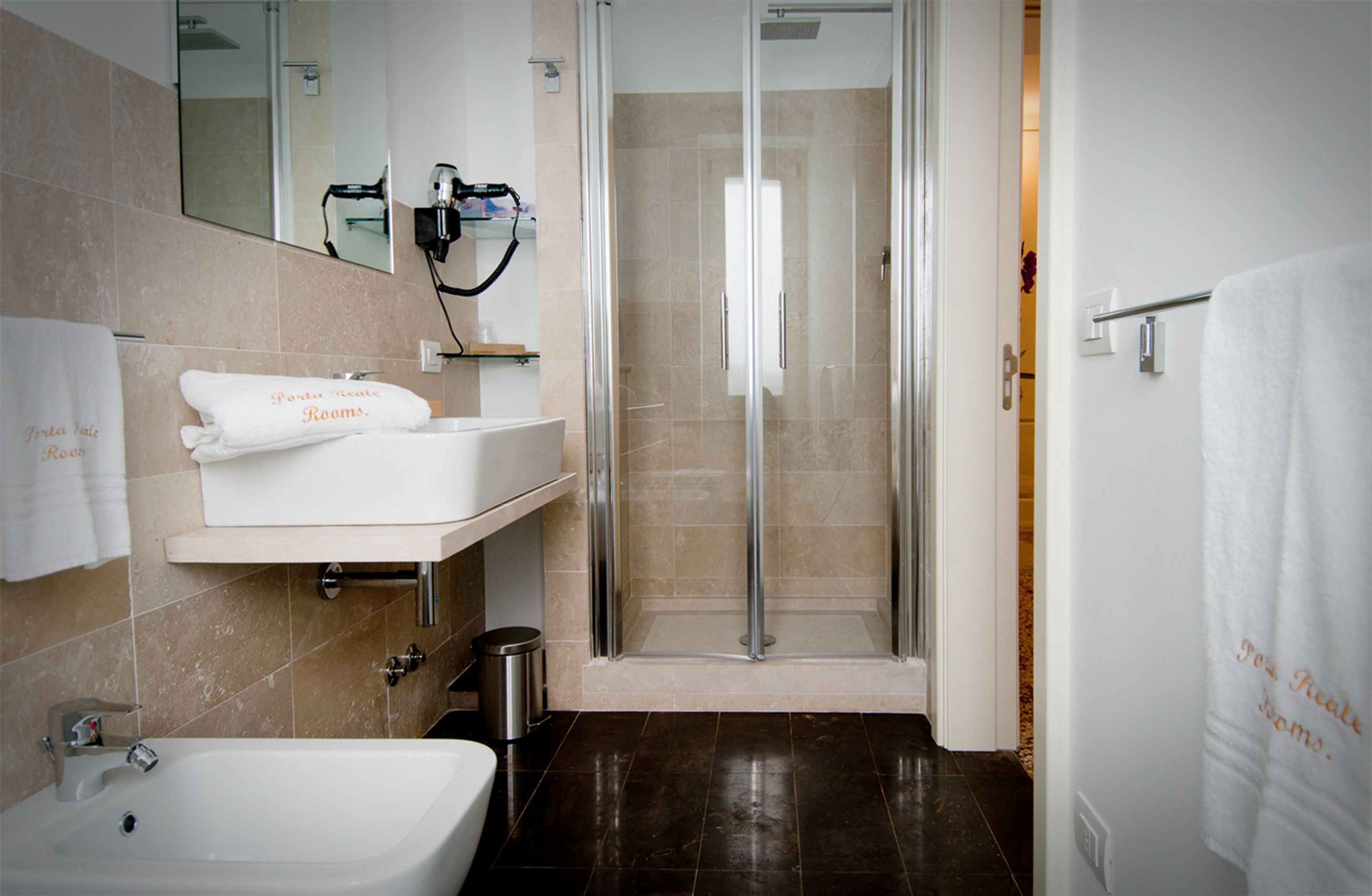 Une salle de bain moderne avec une douche à parois de verre, un lavabo et un miroir.