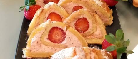 A dessert platter with sliced pastries and strawberries.