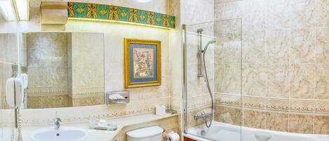 A bathroom with two sinks, a toilet, a bathtub, and a shower.