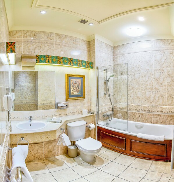 Un baño con dos lavamanos, inodoro, bañera y ducha.