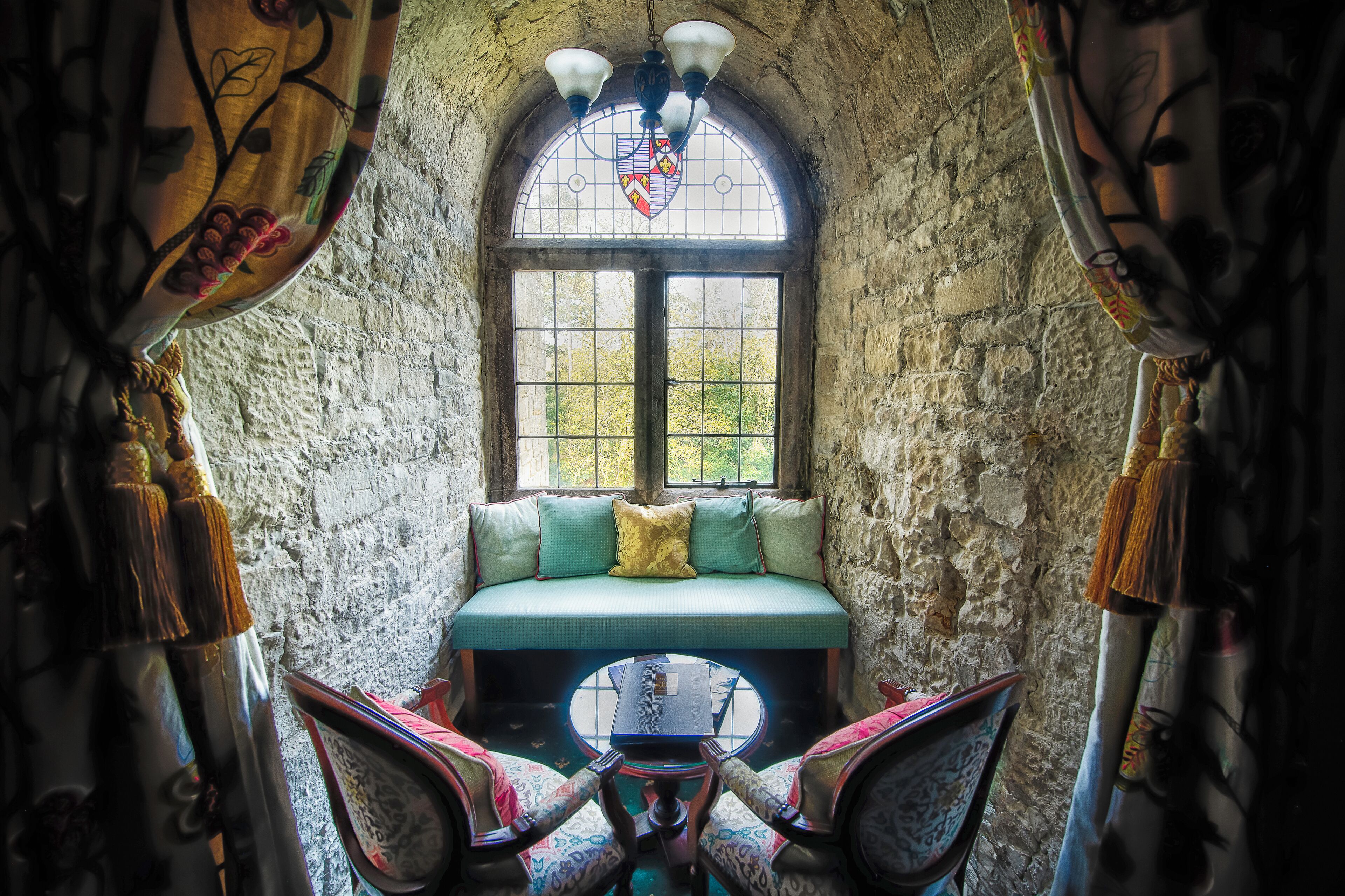 A cozy nook with a cushioned bench, a small table, and a view through a window.