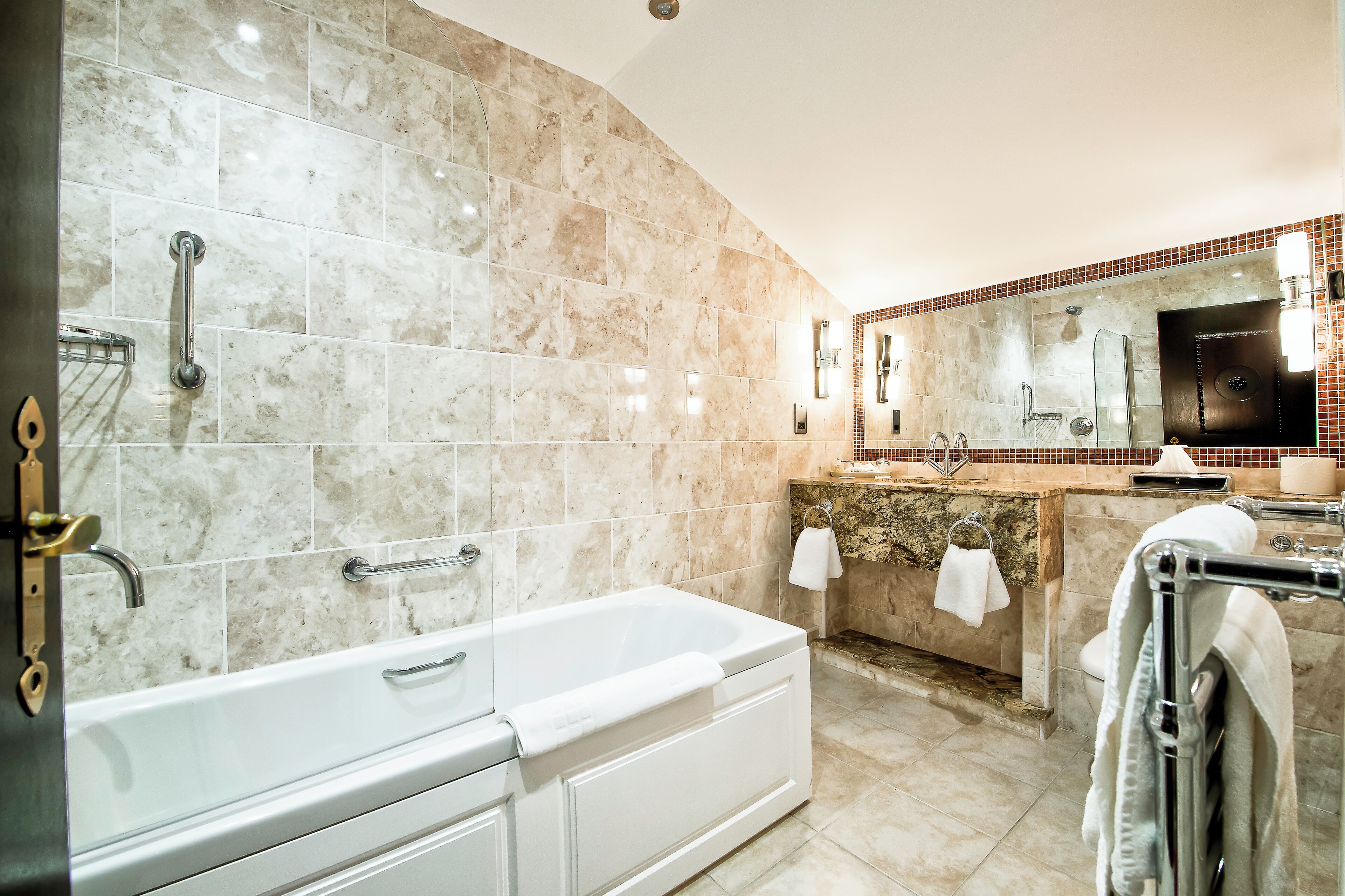 Un baño moderno con una bañera grande, un tocador con espejo y zona de ducha.