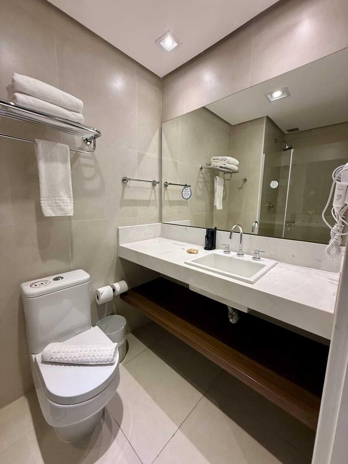 Un baño moderno con inodoro, lavamanos y ducha.