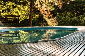Una piscina al aire libre, sillones reclinables de piscina