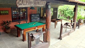 An outdoor pool table area with a sign reading "GALPAO COUNTRY" and another sign indicating "BEM VINDO A POUSA DA NOVA GIRONDA". - Pousada Nova Gironda (Paty do Alferes)