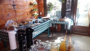 A breakfast buffet with various food items, a coffee station, and a juice bar. - Pousada Nova Gironda (Paty do Alferes)