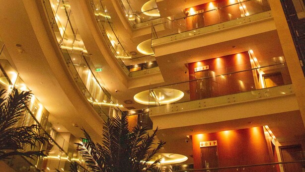 A multi-level atrium with glass railings, multiple floors, and a central spiral staircase. - Ubumwe Grande Hotel (Kigali)