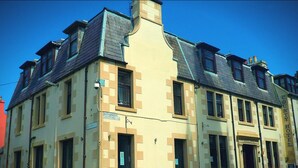 A historic building with a beige facade, multiple windows, and a prominent entrance. - County Hotel (Stornoway)