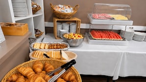 Ein reichhaltiges Buffet mit Croissants, Früchten und verschiedenen Speisen.
