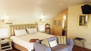 A bedroom with a large bed, a sofa, a nightstand, and a mirror. - On the Beach 1, Langebaan 2-Sleeper (Langebaan)