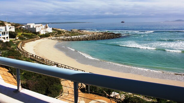 A coastal view with a beach, ocean, and buildings. - On the Beach 1, Langebaan 2-Sleeper (Langebaan)