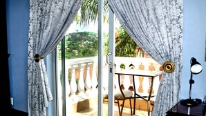 A room with a sliding glass door leading to a balcony with a table and chairs.