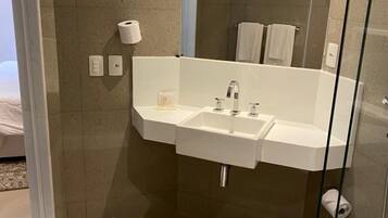 Une salle de bain moderne avec une douche à parois de verre, un meuble-lavabo à deux vasques et des toilettes.