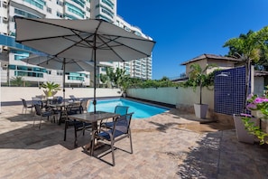 Una piscina al aire libre, tumbonas