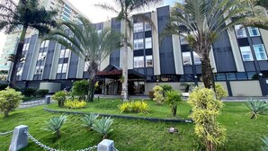 A modern hotel with a central entrance, surrounded by palm trees and well-maintained lawns. - DOM Barra Hotel (Rio de Janeiro)