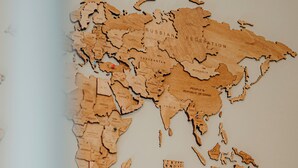 Un mapa de madera del mundo con fronteras y nombres de países.